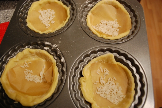 Mini-tarts with parchment paper and rice for baking